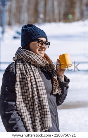woman with cup of hot drink on snowy winter. vertical