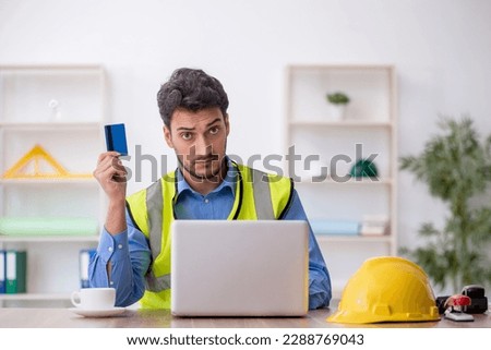 Young male architect holding credit card