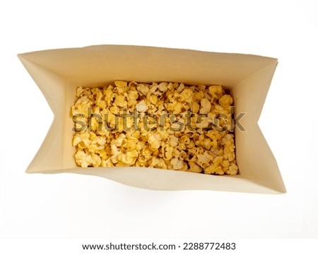 Popcorn in a cardboard box on a white background. Sweet popcorn on white. Close-up.