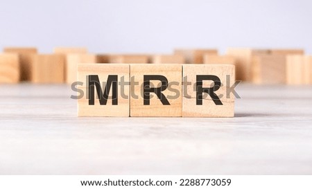 MRR - acronym concept written on wooden cubes or blocks on a light grey background