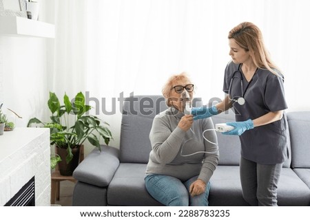 Elderly woman using inhaler for asthma and respiratory diseases at home Royalty-Free Stock Photo #2288783235