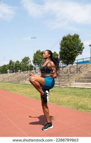 Athletic Black woman exercising by doing jump rope on a running track Royalty-Free Stock Photo #2288789863