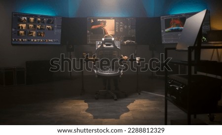 The editor works in studio on computer, edits video, makes color correction for movie post production. Big screens showing color grading program interface with film footage, RGB graphic and levels. Royalty-Free Stock Photo #2288812329