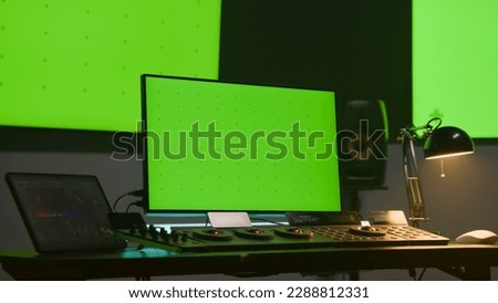 Studio with modern equipment for color correction. Computer and big monitors with green screen. Video editing software interface on digital tablet screen. Color grading control panel. Post production.
