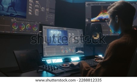 Female editor uses color grading control panel, edits video, makes movie color correction on computer and tablet in studio. Film footage and RGB wheels on monitor. Big screens with program interface. Royalty-Free Stock Photo #2288812335