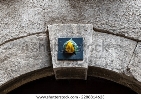 Lemon decoration above the arch on one of the streets in Limone sul Garda, Italy Royalty-Free Stock Photo #2288814623