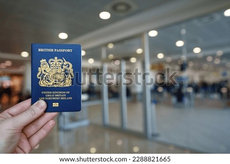 Man holding passport of United Kingdom. Royalty-Free Stock Photo #2288821665