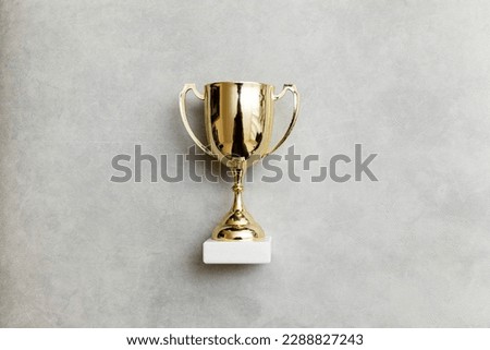 Simply flat lay design winner or champion gold trophy cup on concrete stone grey background. Victory first place of competition. Winning or success concept. Top view copy space Royalty-Free Stock Photo #2288827243