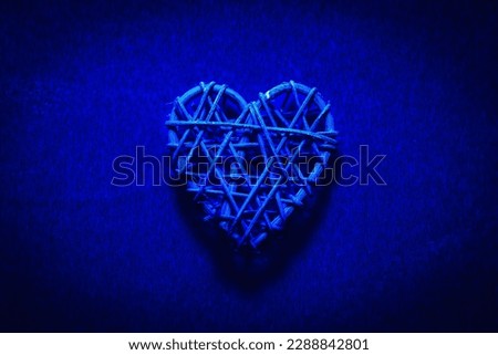 Wooden wicker heart. Rattan work in the shape of a heart. Love concept. Background with selective focus and copy space. On colored foil. Vignetting effect.