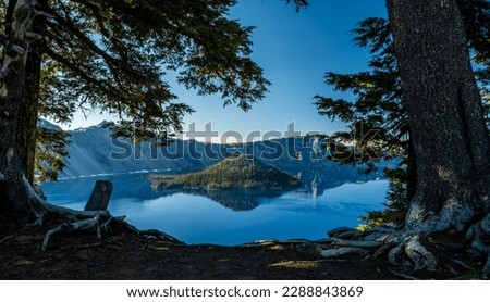 Reflective Blue Waters of Crater Lake between pine trees in summer Royalty-Free Stock Photo #2288843869