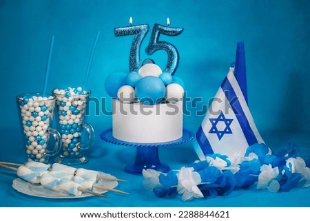 The concept of the Israeli holiday Independence Day, a birthday cake with candles in the form of the number 75, attributes symbolizing the holiday Royalty-Free Stock Photo #2288844621