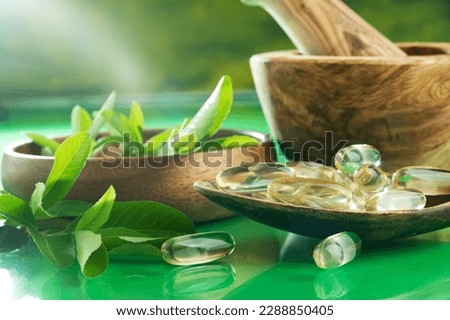 Medicinal herb. Herbal pills with healthy medicinal plant. Green leaf. Natural pharmaceutical capsule. Vitamin supplement for care and treatment. Alternative medicine. Royalty-Free Stock Photo #2288850405