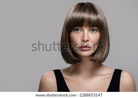 Portrait of beautiful fashion woman with bob hairstyle. Thick short wig. Gray background Royalty-Free Stock Photo #2288853147