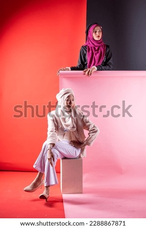 Young smiling confident asian muslim woman in hijab over isolated over background studio. Casual hijab fashion.