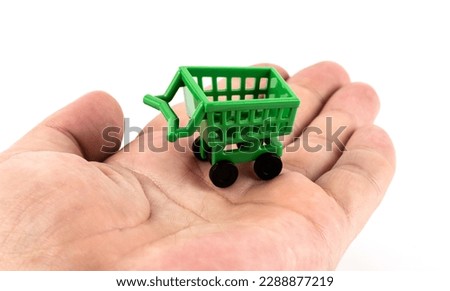 Miniature shopping cart from a supermarket on a man's palm