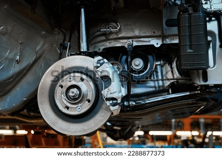 Finished automobile suspension with brake and rotor in shop Royalty-Free Stock Photo #2288877373