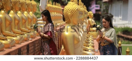 Young Asia girl with Thai traditional costume  Sprinkle water onto a Buddha image, Songkran festival or Thailand new year concept 