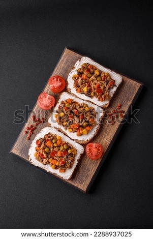 Delicious veggie sandwiches with canned tuna and Mexican mixed vegetables on a dark concrete background