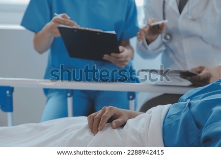 Injured patient showing doctor broken wrist and arm with bandage in hospital office or emergency room. Sprain, stress fracture or repetitive strain injury in hand. Nurse helping customer. First aid. Royalty-Free Stock Photo #2288942415