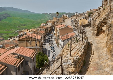 group of cyclists climbs the hill in single file entering a town in central Sicily Royalty-Free Stock Photo #2288951047