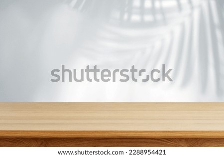 Aesthetic Wooden Table with realistic tropical leaves shadow overlay effect white wall Royalty-Free Stock Photo #2288954421