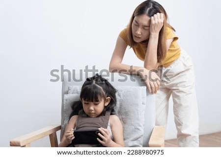 Asian mother feeling worried her daughter game addiction. Royalty-Free Stock Photo #2288980975