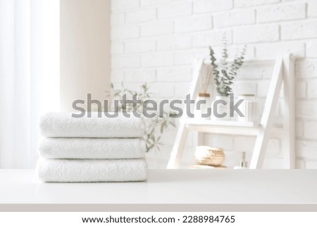 Spa towel stack on white table on bathroom interior background Royalty-Free Stock Photo #2288984765