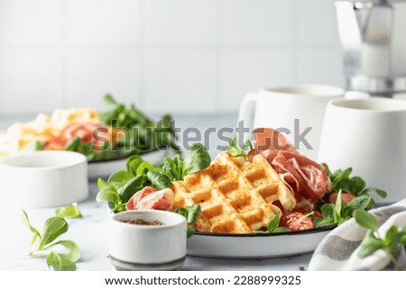 Cheesy belgian waffles served with ham, tomatoes and lettuce corn on white marble background . Savory waffles. Healthy breakfast. Text space. Horisontal Royalty-Free Stock Photo #2288999325