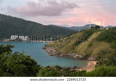 Panoramic view from Windmill sunset viewpoint in Phuket island in Thailand. Purple skies above the azure sea bay and tropical sandy beach. A lonely windmill is on the top of the hill. Royalty-Free Stock Photo #2289013725