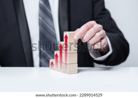 Wooden blocks with red arrows icons, business profit growth success concept