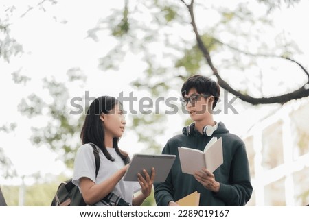 Asian students joining study book reading together.