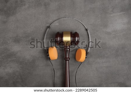 Music piracy and copyright protection law concept, gavel, tape recorder and headphones on table, top view Royalty-Free Stock Photo #2289042505