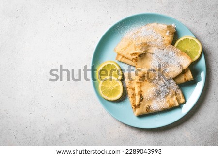 Lemon crepes on white background, copy space. Homemade french citrus Crepes for breakfast or dessert. Royalty-Free Stock Photo #2289043993