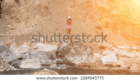 Woman travel sea. Happy tourist in pink bikini enjoy taking picture outdoors for memories. Woman traveler posing on the beach at sea surrounded by volcanic mountains, sharing travel adventure journey