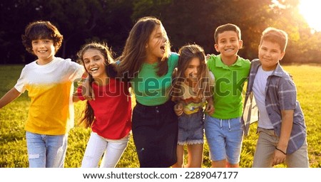 Happy children playing in park and having fun together. Bunch of excited little friends enjoying summer break, walking on sunny meadow and hugging each other. Header, banner. Kids, friendship concept