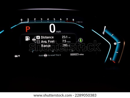 Illuminated instrument panel dashboard on new car with very low milage at only 23 miles odometer, digital display of gauges and indicators, fuel level, engine temperature. Modern driving technology Royalty-Free Stock Photo #2289050383