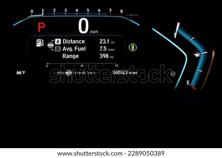 Illuminated instrument panel dashboard on new car with very low milage at only 23 miles odometer, digital display of gauges and indicators, fuel level, engine temperature. Modern driving technology Royalty-Free Stock Photo #2289050389