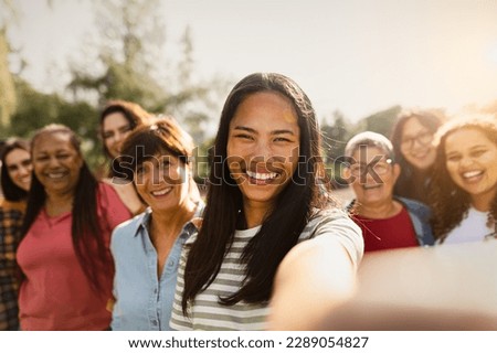 Happy multigenerational group of women with different ethnicities having fun taking selfie with smartphone camera in a public park - Females empowerment concept Royalty-Free Stock Photo #2289054827