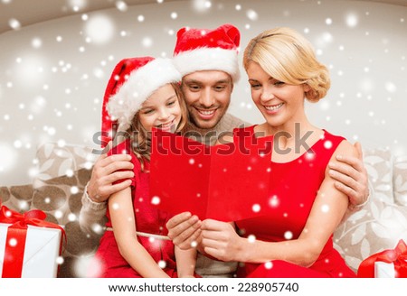 family, christmas, greetings and people concept - smiling family in santa helper hats with many gift boxes reading postcard at home