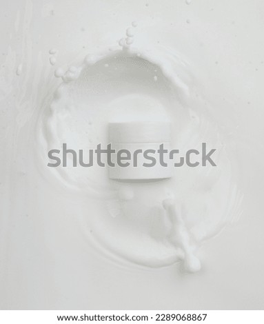 Cosmetic container white lotion droplet fly splashing. Milk lotion pour float to cosmetic bottle. Moisturizer lotion explosion spill. White background isolated high speed shutter freeze top view Royalty-Free Stock Photo #2289068867