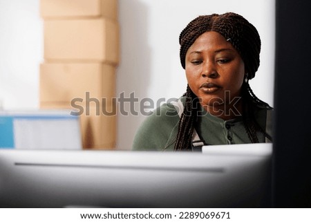 Warehouse worker looking products quality control report on computer, working at merchandise inventory. Stockroom manager checking customers orders, preparing packages for delivery
