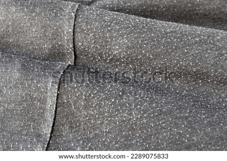 Fuzzball on the gray cotton knitwear fabric. Lint balls on the clothes. Pill on the wearout t-shirt. Royalty-Free Stock Photo #2289075833