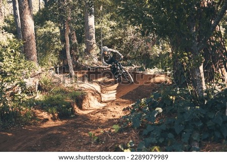 Trail, mountain bike and man cycling in the forest or woods fast, speed and adrenaline in training. Extreme sports, bicycle and rider biking for exercise, fitness and workout in nature for wellness Royalty-Free Stock Photo #2289079989