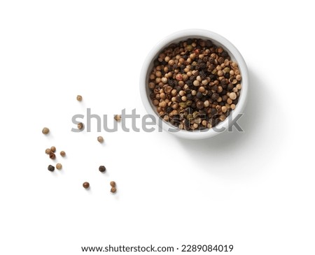 small bowl of peppercorns and scattered peppercorns top view, isolated on white background Royalty-Free Stock Photo #2289084019