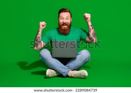 Full length photo of impressed lucky man wear t-shirt winning game modern gadget rising fists isolated green color background
