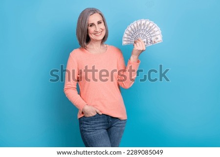 Photo of positive good mood lady dressed coral shirt rising money cash fan isolated blue color background