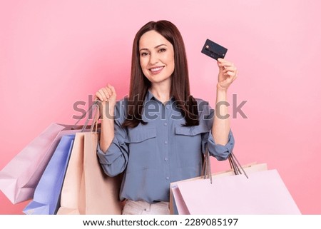Photo of positive stunning lady shopaholic shopper wear blue trendy clothes showing card nfc fast payment isolated on pink color background