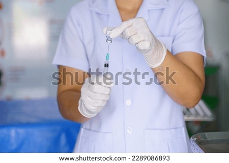 The doctor prepares the vaccination needle.
