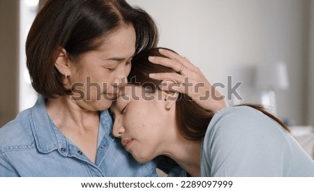 Middle aged asia people old mom love care trust comfort help young teen talk crying stress relief at home. Mum as friend listen adult child woman feel pain sad worry of broken heart life crisis issues Royalty-Free Stock Photo #2289097999