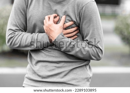 Man covering his heart or chest outdoors, concept of heart attack.  Royalty-Free Stock Photo #2289103895
